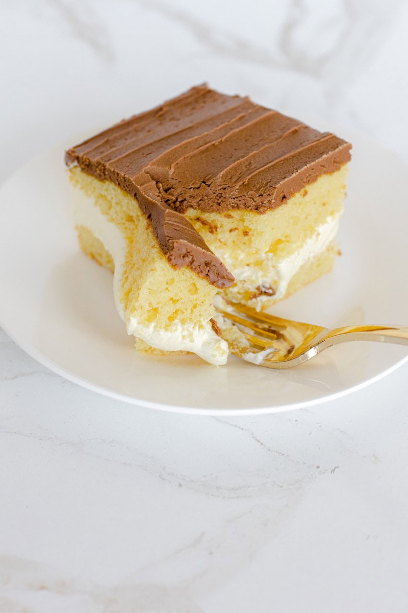 Vanilla Cream Filling in the Center of a Yellow Cake with Chocolate Frosting.