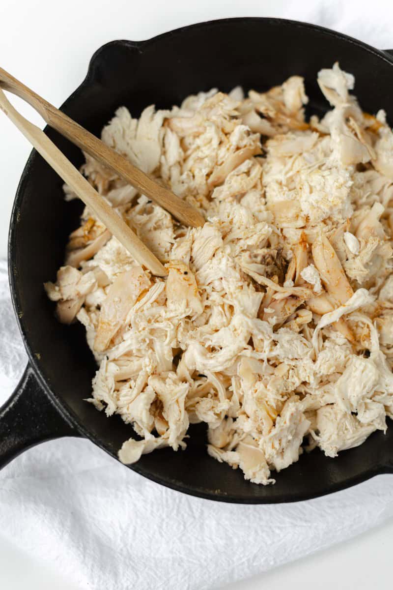 Smoked Shredded Chicken in a Cast Iron Pan with a Serving Tong 