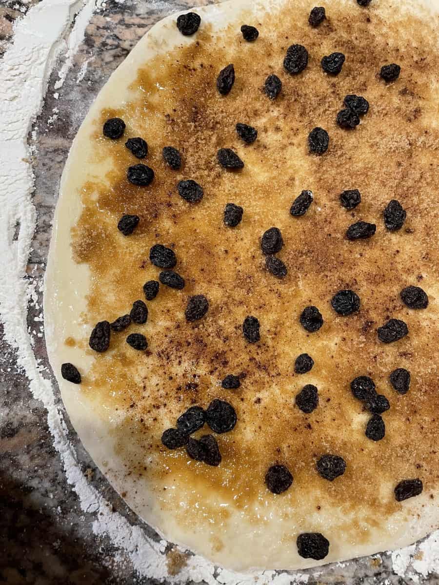 Top the dough with a layer of Brown Sugar, a Sprinkle of Ground Cinnamon and Raisins