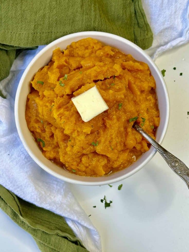 A Bowl of Mashed Butternut Squash with a Pat of Butter on top.