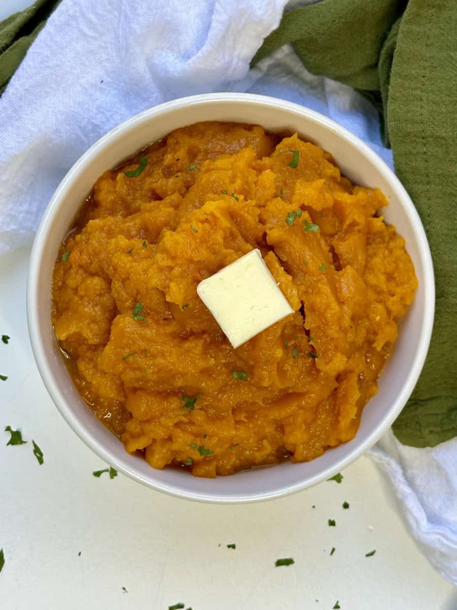 Garnish the mashed squash with a pat of butter and some fresh parsley pieces.