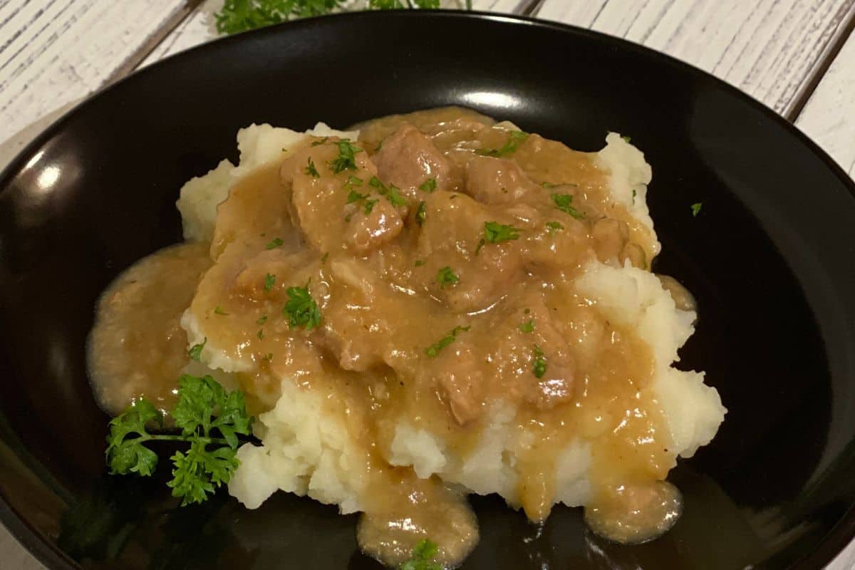 Braised Pork Tenderloin in a savory gravy over mash potatoes