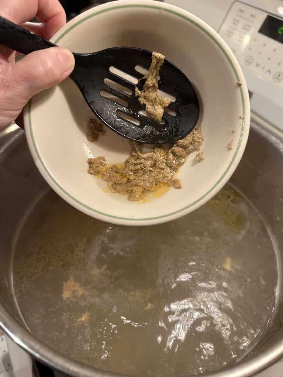 Cleaning the scum off the top of the boiling water