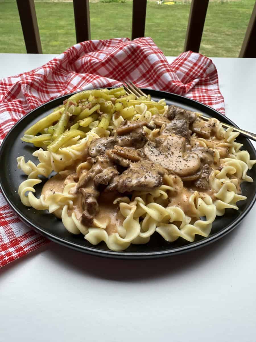 Creamy Elk Backstrap Recipe with Mushrooms on a plate with cooked yellow beans