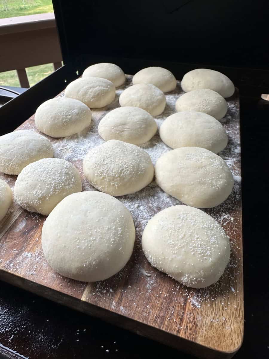 Raised English Muffin Dough Balls on a wooden board