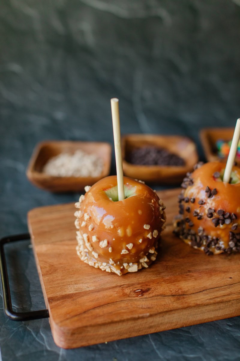 Homemade Caramel Apples displayed on a Wooden Board