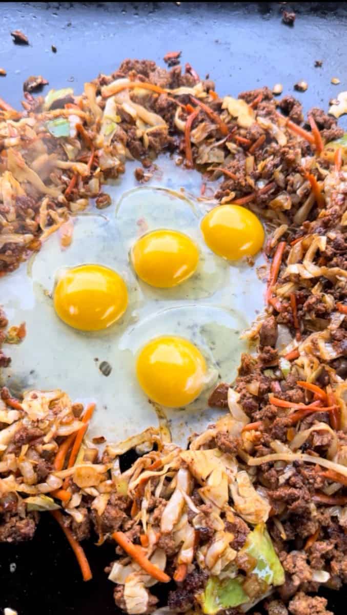 Griddle Eggs cooking around Egg Roll in a Bowl Mixture