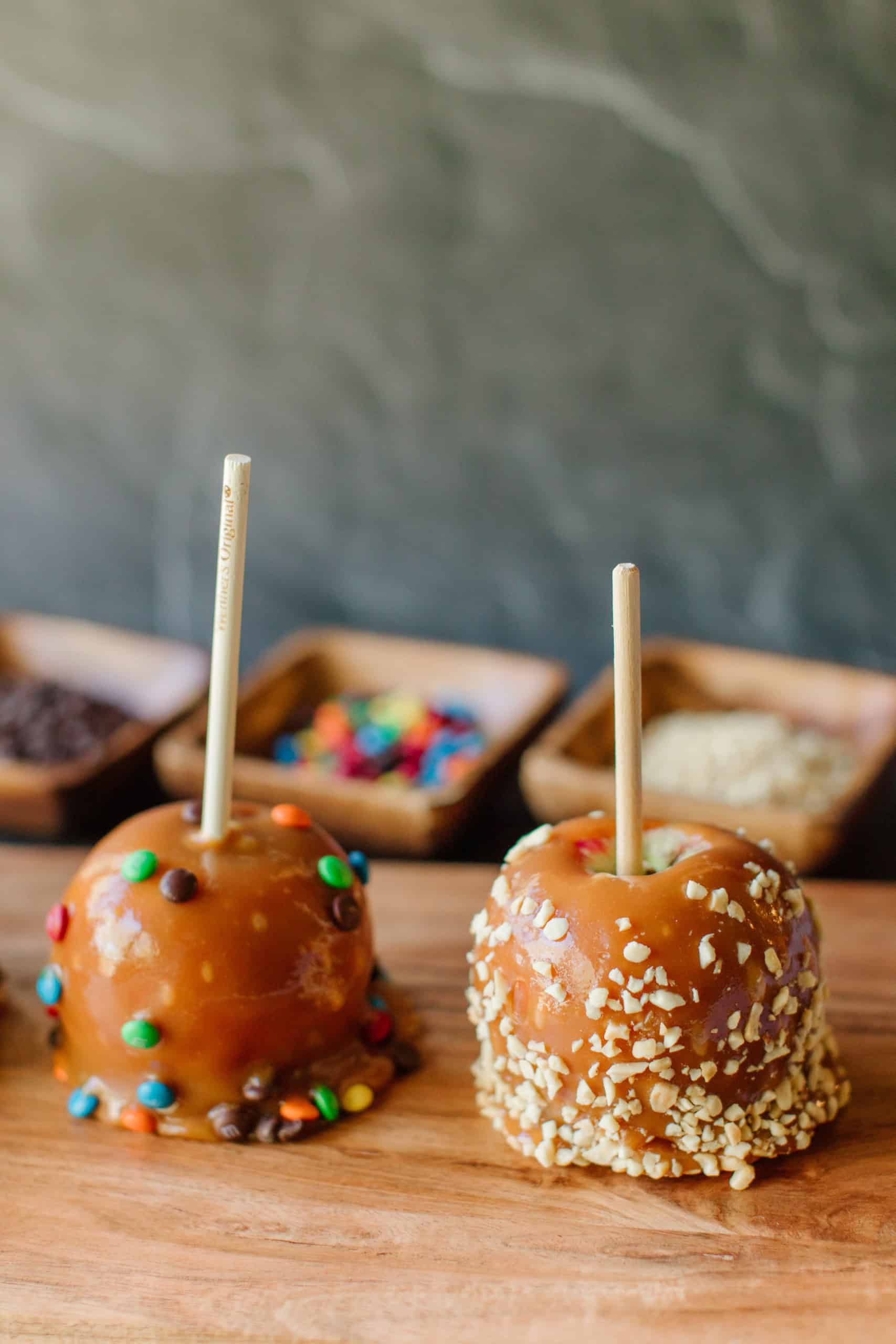 Two Caramel Apples on a Wooden Board