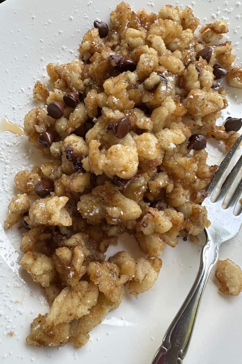 Blackstone Griddle Scrambled Pancakes topped with Chocolate Chips and Syrup on a serving plate