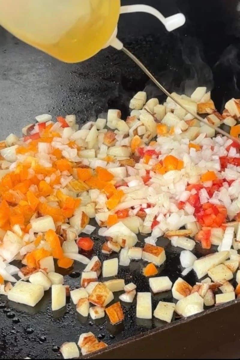 Adding Oil to Diced Potatoes, Peppers and Onions