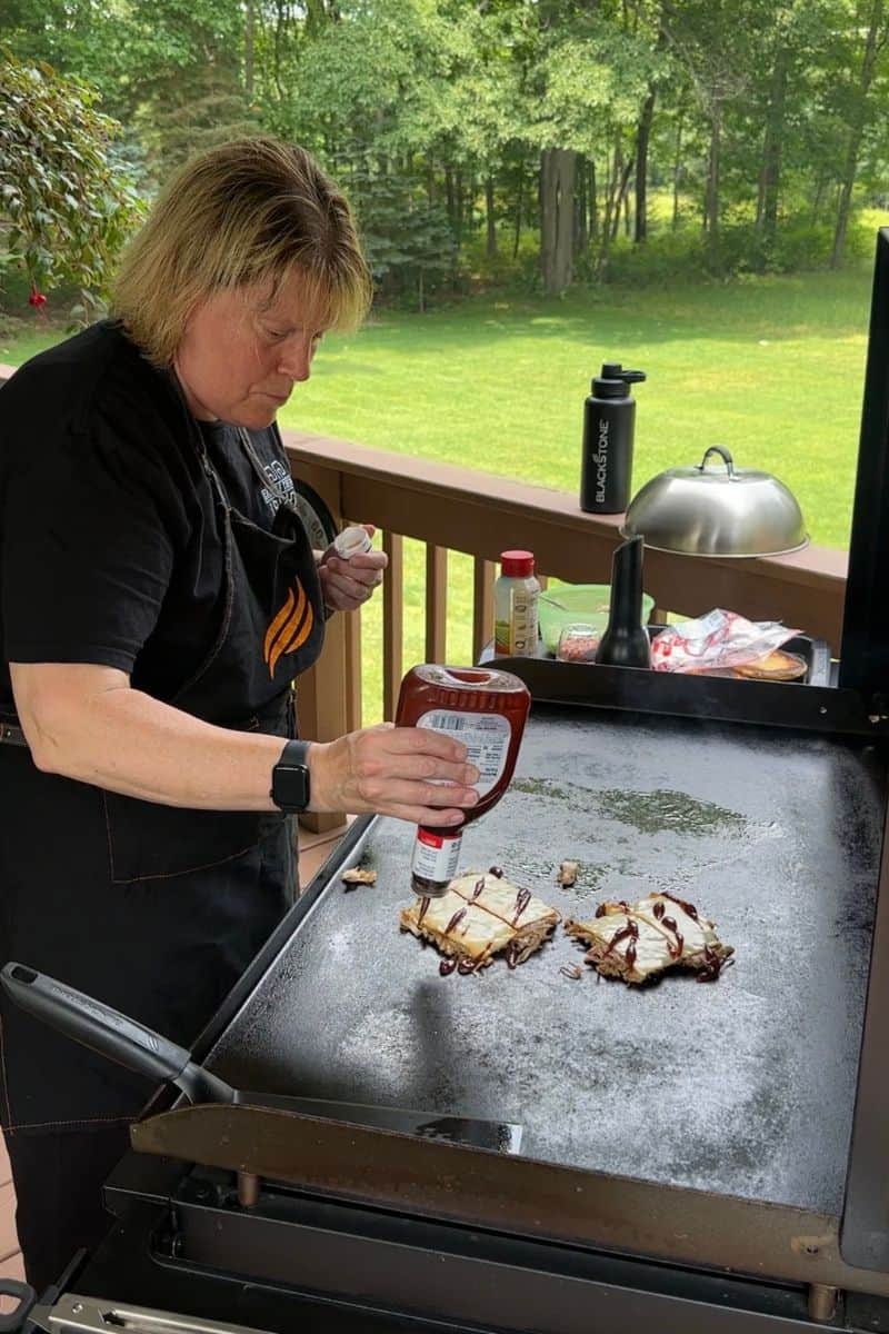Chef Sherry Ronning Drizzling BBQ Sauce over the Pulled Pork Smash Burgers